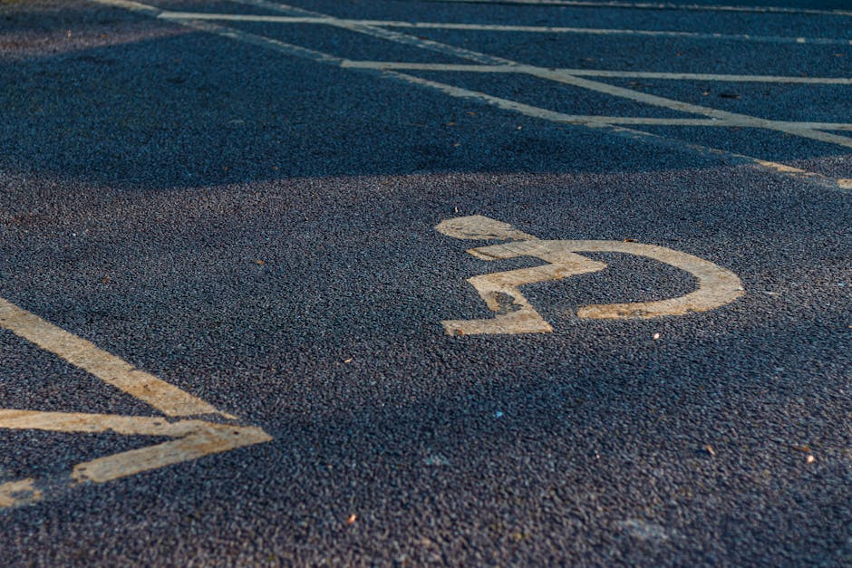 Close-up view of a parking space dedicated for moving vehicles, with the number '22' painted in white on dark asphalt. The parking area is marked with additional white lines and symbols, indicating designated zones for loading and unloading during home relocation or furniture transport. In the background, part of a driveway or street can be seen, along with a curb, suggesting an exterior environment suitable for vehicle access by a removal van associated with Man with Van Belvedere. The scene captures the typical setting where professional removals services operate, supporting the logistics of packing and moving while ensuring proper access and parking permissions for efficient furniture transport and house removals.